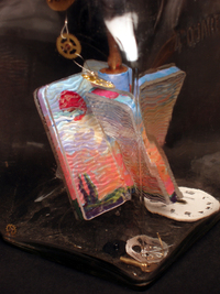 <div class='title'>Day Churns into Night</div><br>Vintage butter churner, acrylics, glass, watch parts<br>14"w x 8"h x 5.5"d<br>