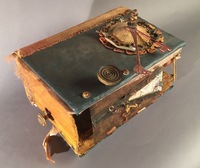 <div class='title'>Mama Mia</div><br>Vintage encyclopedia, found objects of metal wood, fabric, doll parts, photo of artist's painting on canvas, copper-backed glass tiles, mirror, vintage pins and fabric, vintage letter, soil <br>Closed: 8"w x 8"h x 14"d; Open: 6"w x 18.5"h x 14"d<br>