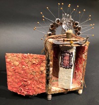 <div class='title'>The Thread That Binds Us</div><br>Flameworked hand, photos of artists portraits, vintage book cover, hinges, zipper, artist-made tatting, fescue seed, weeds, mirror, sewing pins, egg shells, fabric, metal parts, thread, copper foil, acrylics <br>Closed: 11"w x 7.5"h x 5"d; Open: 11"w x 10"h x 5"d<br>