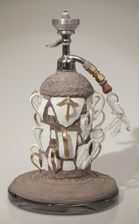 <div class='title'>Get a Grip</div><br>Flameworked figure and eye, seltzer bottle, china cup handles, brass chain, grout <br><a href='videos/663.mov' target=_blank>VIDEO!</a><br>14"h x 10"d<br>